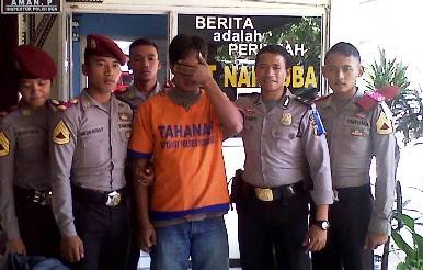 Tersangka Sumarto digelandang petugas di Mapolres Sidoarjo. (foto: nanang ichwan/BANGSAONLINE)