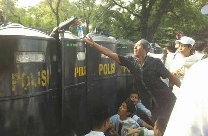 Suasana akrab aparat dan pengunjukrasa dalam aksi damai menuntut penuntasan kasus Ahok Jumat (4/11) sebelum akhirnya pecah kerusuhan. 