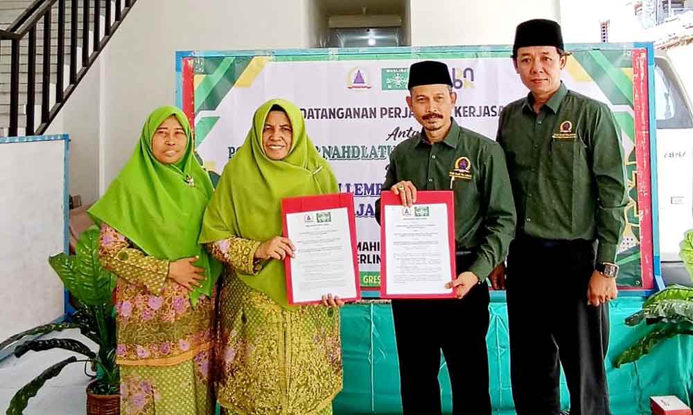 Andi Fajar Yulianto (dua dari kanan) didampingi Muhlis bersama Ketua PC Muslimat NU Kabupaten Gresik, Hj. Aliyah Ghozali menunjukkan MoU. (Ist)