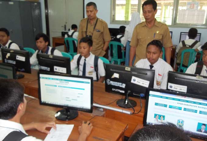 Siswa PPDB sedang melakukan pendaftaran PPDB online dipandu para guru agar tidak sampai mengulang maupun salah. foto: BAMBANG/ BANGSAONLINE