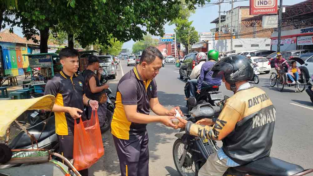 Personel Bag SDM Polres Mojokerto membagikan bubur kacang hijau kepada warga di sekitar Stasiun Mojokerto. (Ist)