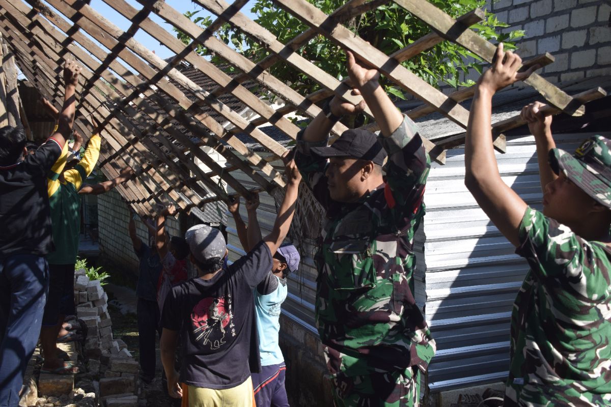 Warga bersama anggota Kodim 0811 Tuban saat membongkar rumah Mbah Nuryanto sebelum nantinya direnovasi
