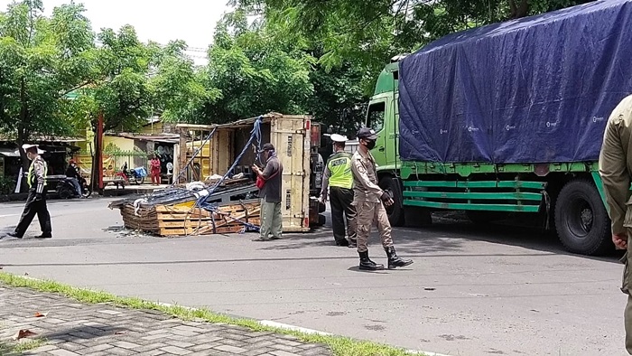 Petugas Polsek Tandes dibantu Satpol PP sedang melakukan pengamanan di lokasi truk terguling. foto: NANANG FACHRUROZI/ BANGSAONLINE