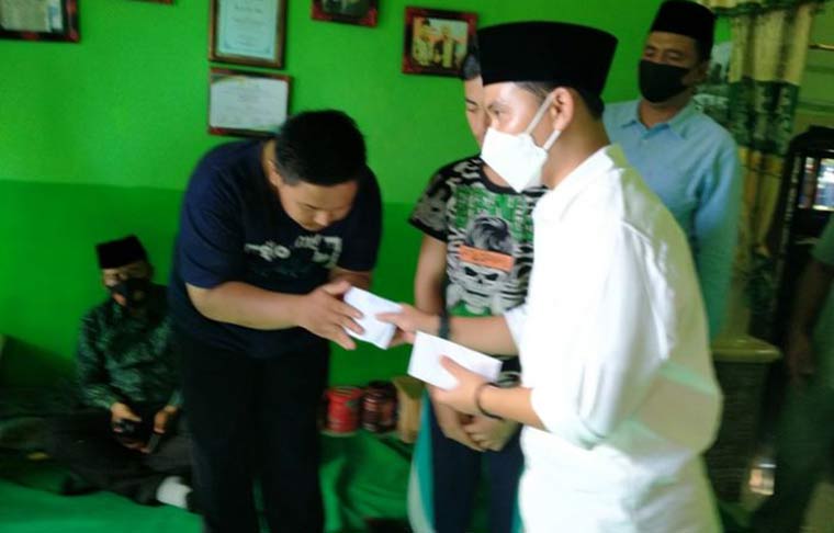 Muhammad Al-Barra (Gus Barrra), putra tertua Prof. Dr. KH. Asep Saifuddin Chalim saat memberikan santunan uang kepada dua anak suami-istri, yang meninggal karena tertimpa batu saat terjadi gempa pada Sabtu (11/4/2021). foto: mma/ bangsaonline.com