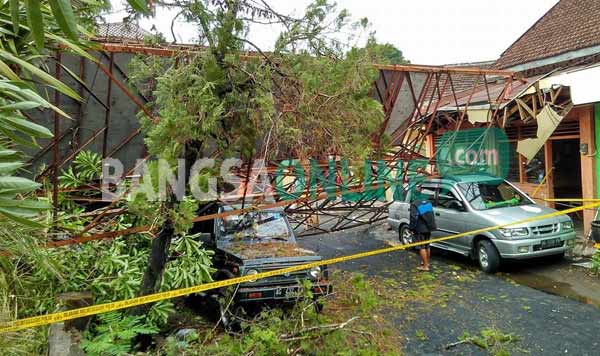 Sebuah mobil tertimpa menara panjat tebing di Taman Sekartaji Kota Kediri. foto: arif kurniawan/BANGSAONLINE