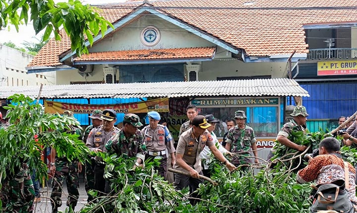 Kapolresta Sidoarjo Kombes Pol Zain Dwi Nugroho ikut membersihkan ranting-ranting pohon usai dipotongi.