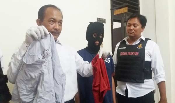 Tersangka cabul diapit anggota Crime Hunter Polsek Wonokromo. foto: ekotuyono/ BANGSAONLINE
