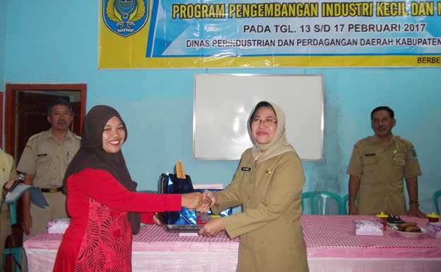 Penyerahan alat jahit secara simbolis oleh Kepala Disperindag Nganjuk, Heni Rochtanti, kepada salah satu peserta pelatihan Menjahit. foto: INTAN/ BANGSAONLINE