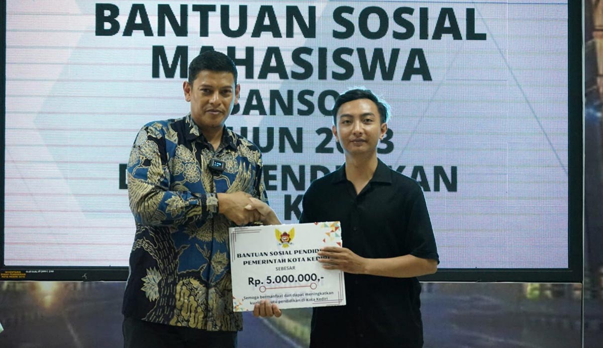 Wali Kota Kediri Abdullah Abu Bakar saat menyerahkan bantuan sosial pendidikan kepada salah seorang mahasiswa. Foto: Ist.