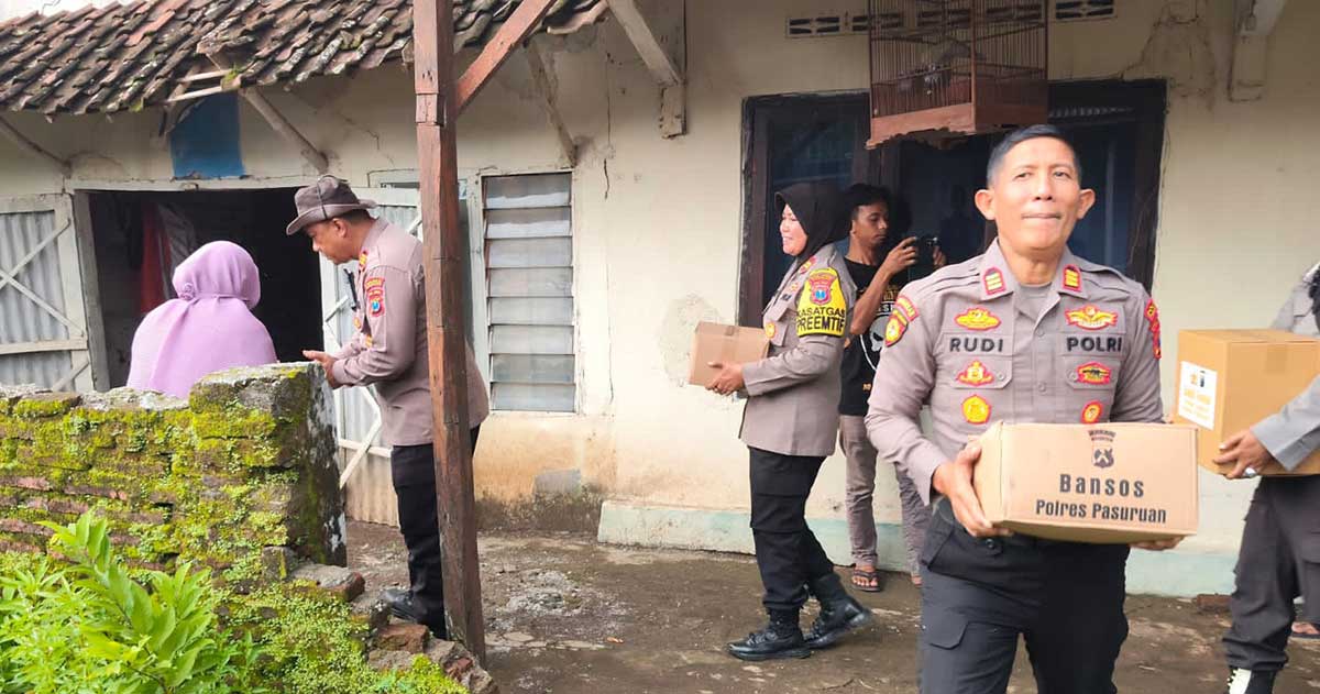 Petugas dari Polres Pasuruan saat menyalurkan bantuan untuk warga terdampak puting beliung di Desa Klangrong, Kecamatan Kejayan.