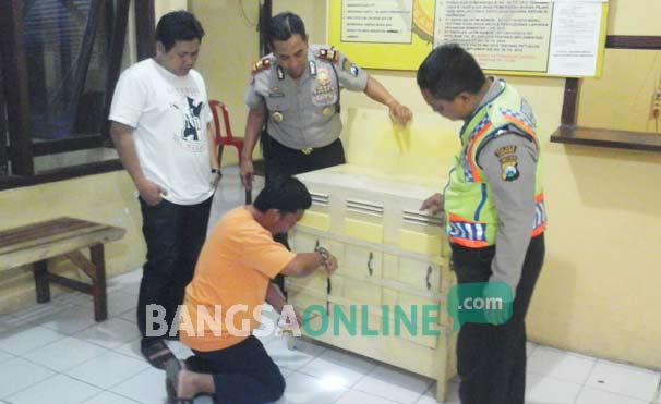 Tersangka pencuri kotak amal (persembahan) gereja saat peragakan aksinya di Mapolsek Jombang Kota. (ft-romza / BANGSAONLINE)