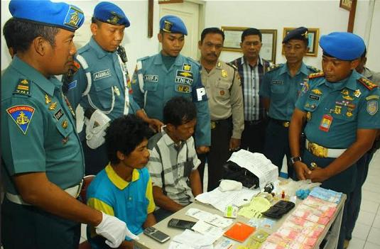 Kedua tersangka ketika menjalani pemeriksaan petugas Bandara Juanda setelah kedapatan bawa upal Rp 109 juta. Foto: catur andy erlambang/ BANGSAONLINE


