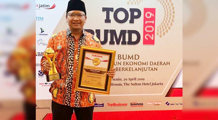 Irsyad Yusuf memamerkan piagam dan trofi penghargaan.