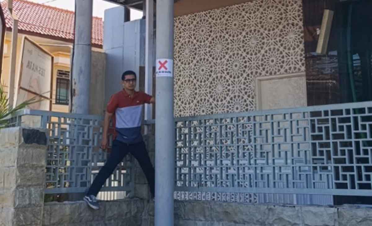 Petugas saat menunjukkan papan reklame jenis videotron yang disegel karena tak kantongi izin. Foto: Ist