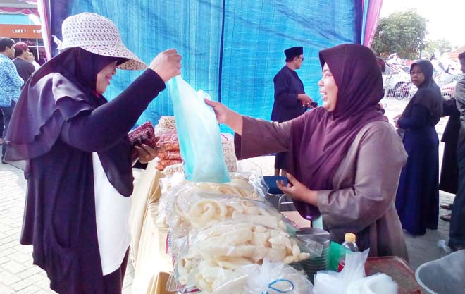 Andriah Astuti saat melayani pembeli. 