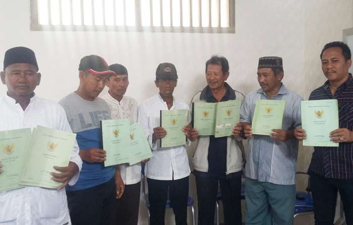 Delapan petani garam menunjukkan sertifikat tanah yang dimilikinya.