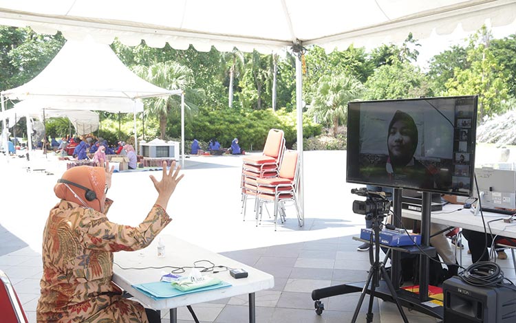 Wali Kota Risma menyapa dan memberikan motivasi kepada ribuan pelajar Kelas VI SD se-Surabaya melalui teleconference di Dapur Umum Covid-19 Balai Kota Surabaya, Jumat (15/5/2020). (foto: ist)