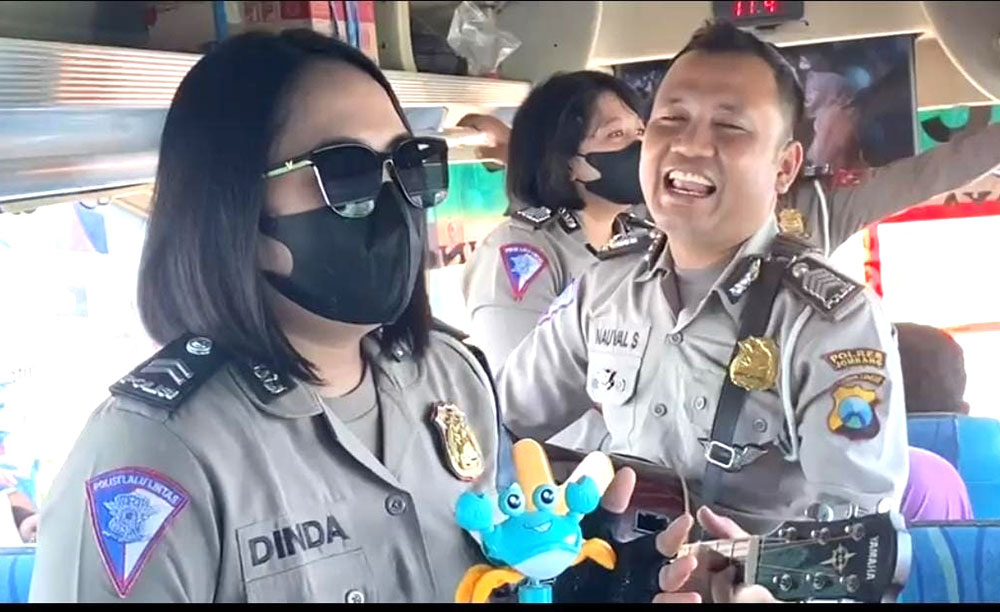 Anggota Satlantas Polres Jombang saat mengamen untuk menghibur pemudik di atas bus.