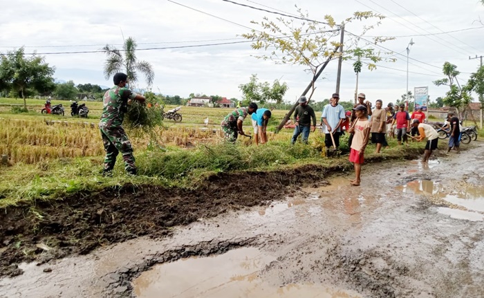 Anggota Babinsa bersama warga Desa Rejuno sedang bergotong royong membersihkan aliran sungai/parit.