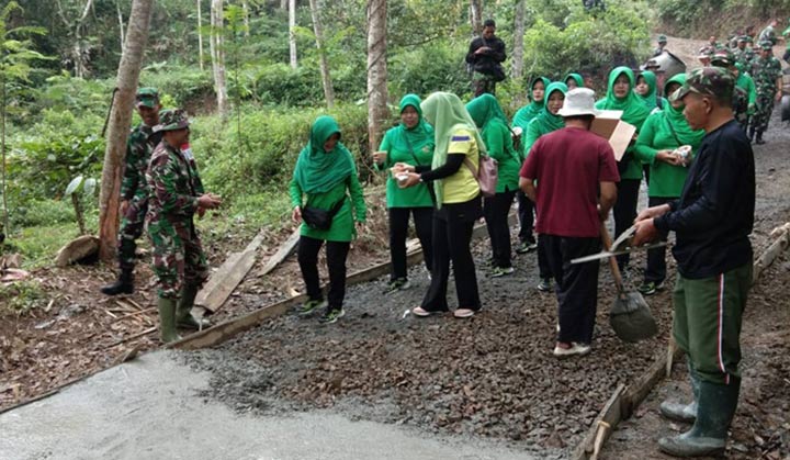 Ibu-ibu Persit KCK Cabang XX Kodim 0806 Trenggalek saat membagikan bubur kacang hijau kepada Satgas TMMD dan warga.