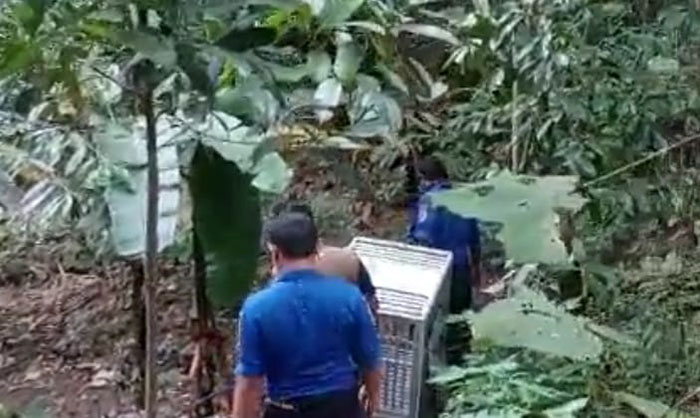 Petugas dari BKSDA Kediri saat membawa alat jebakan ke arah sungai munculnya anak buaya. Foto: Ist