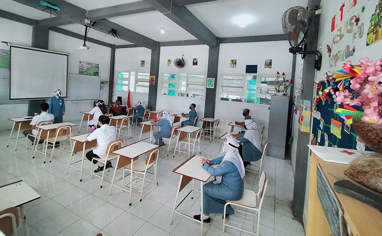 Para Guru SMPN 15 Surabaya saat sedang melakukan simulasi PMB di ruang kelas dan sebelum masuk kelas. (foto: ist).