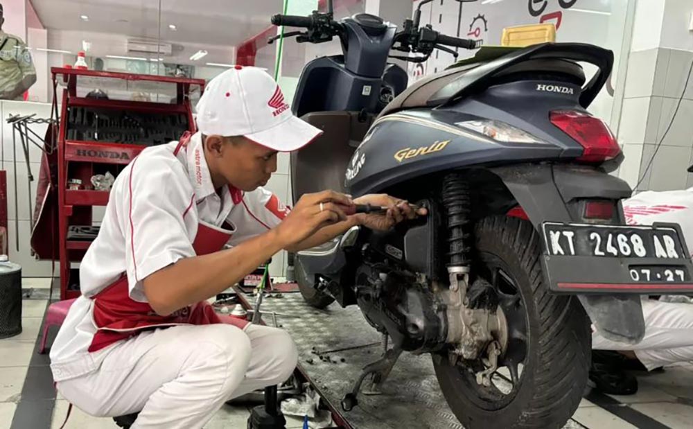 Mekanik AHASS saat sedang memeriksa motor yang mengalami brebet.