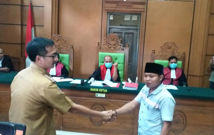 dr. Farhat Suryaningrat berjabat tangan dengan Moh. Hosen (terdakwa) usai sidang kedua di PN Negeri Bangkalan.