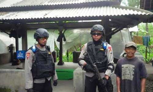 Polisi berjaga sesaat setelah penangkapan dua terduga teroris oleh Densus 88 Mabes Polri, di Makam Setyo Setuhu, Dusun Keramat, Desa Patokpicis, Kecamatan Wajak, Kabupaten Malang, Selasa (1/3). foto: beritajatim