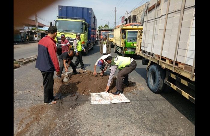 ​Prihatin Jalan Rusak, Polantas dan Warga Kejapanan Pasuruan Perbaiki Jalan