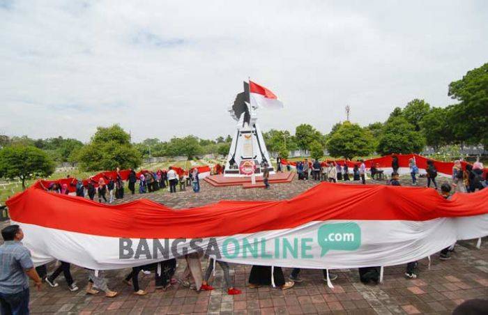 Mahasiswa Bentangkan Bendera Sepanjang 80 Meter di Taman Makam Pahlawan Jombang