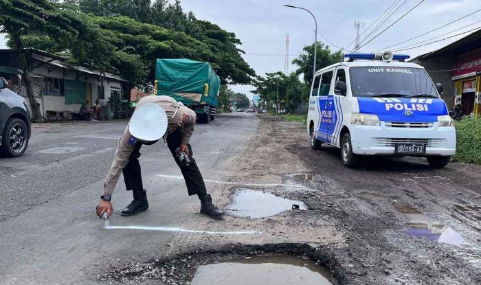 Polisi Kawal Pengaspalan Jalan Rusak di Pantura Situbondo