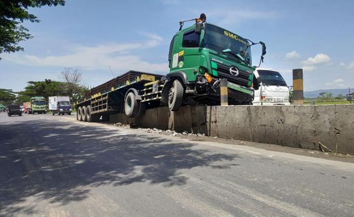 Hilang Kendali, Truk Trailer Muatan Baja di Tuban Nyangkut Pembatas Jalan