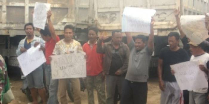 Puluhan sopir demo dengan membawa spanduk berisi kecaman dan tuntutan pada perusahaan agar tidak main pecat. (Suwandi/BANGSAONLINE)
