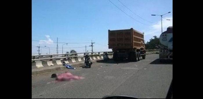 Korban yang tewas  di jalan setelah terlindas truk di flyover Trosobo. Foto : khumaidi/BANGSAONLINE