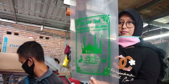 Ari Rahmawati menunjukkan hasil sablon kantong zakat plastik produksinya. foto: AAN AMRULLOH/ BANGSAONLINE