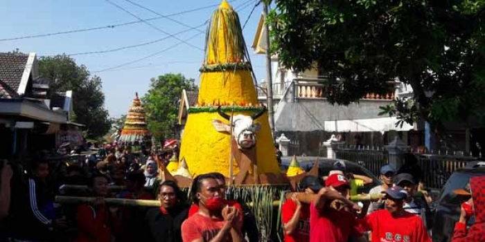 Warga Boteng Kecamatan Menganti ketika mengusung tumpeng raksasa. foto: syuhud/BANGSAONLINE