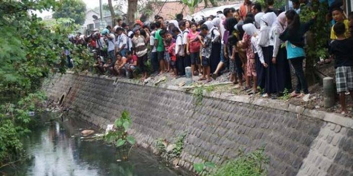 Warga berkerumun ingin melihat mayat yang masih mengambang di sungai. foto: RONY S/ BANGSAONLINE