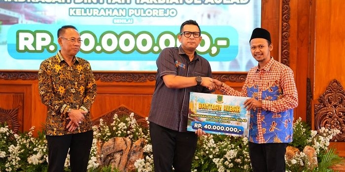 Pj Wali Kota Mojokerto Moh Ali Kuncoro menyerahkan dana hibah secara simbolis didampingi sekretaris daerah.