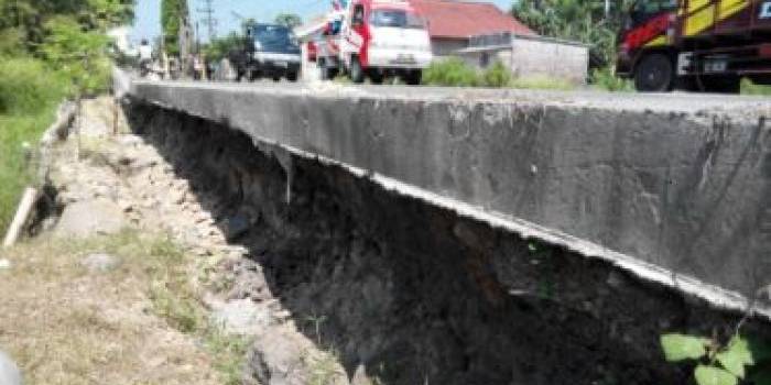 Kondisi jalan raya Kupang-Jetis menganga akibat tergerus hujan. (foto: yudi eko purnomo/BANGSAONLINE)