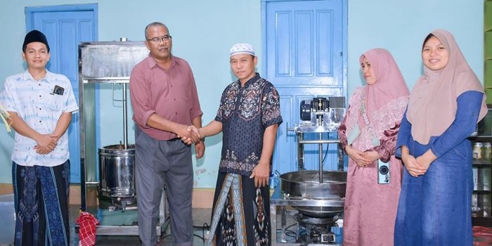 Penyerahan alat kepada UMKM oleh Ketua Tim Pengabdian, Ach. Muhib Zainuri.