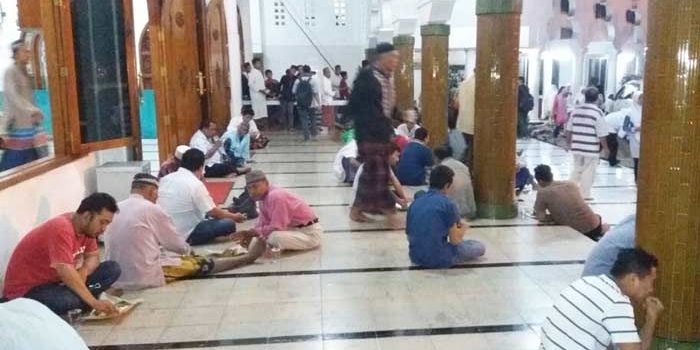 Jamaah Masjid Rahmat Kembang Kuning Surabaya saat menikmati buka bersama yang disediakan sebanyak 500 porsi setiap harinya. foto: YUDI ARIANTO/ BANGSAONLINE