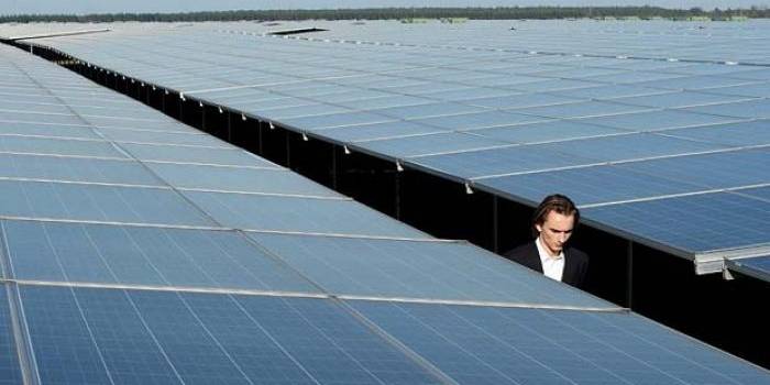 Seorang pria berjalan antara panel Photovoltaic di pusat Energi Matahari, yang baru saja diresmikan 1 Desember 2015, di Cestas kemarin. foto: telegraph.co.uk/AFP/Getty Images
