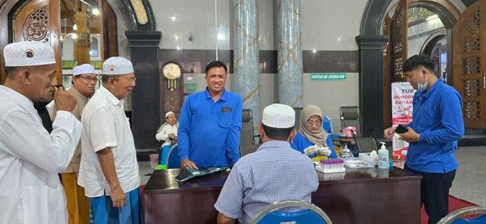 Para takmir Masjid Agung Bangkalan sedang melayani warga yang ingin mengecek kesehatan di Masjid Agung Bangkalan. (Ist)