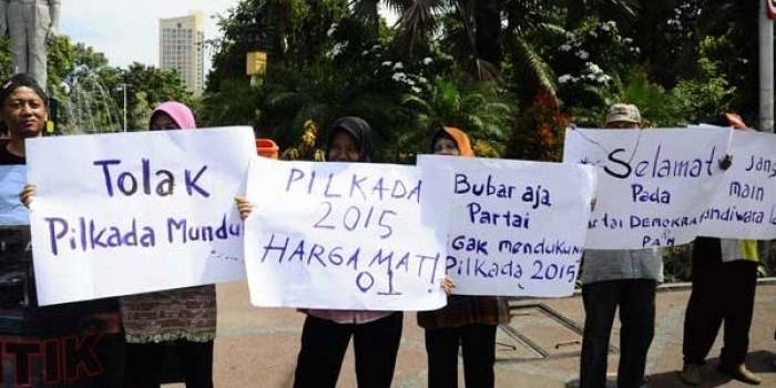 BEBER POSTER – Massa Aliansi Warga Surabaya membeber sejumlah poster menolak Pilwali Surabaya ditunda 2017, di depan Gedung Negara Grahadi, Rabu (9/9). Foto: maulana/BANGSAONLINE