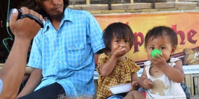 ?Hanifatul Humaira dan Adiknya Hanifatuz Zahra sedang makan konsentrat pakan burung, saat bermain dengan ayahnya, Edy Sunaryo. Foto:hadi prayitno/BANGSAONLINE