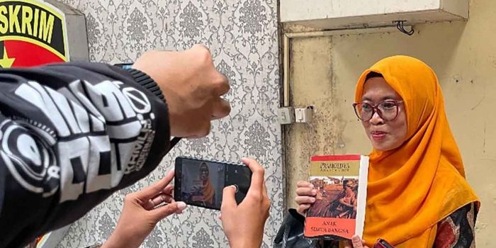 Asfinwati, ibu Faiz saat menunjukkan sebuah buku kepada wartawan. Foto: Ist