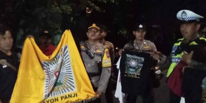 Kapolsek Tambaksari menujukan hasil pengamanan miras dan bendara pesilat saat konvoi 