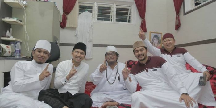 KH Ahmad Muzakki Syah (berkalung tasbih, nomor 3 dari kiri) mengacungkan salam satu jari bersama Emil Elestianto Dardak (nomor 2 dari kiri) dan Ra Fadil (nomor 1 paling kiri), putera Kiai Ahmad Muzakki Syah. Foto: bangsaonline.com