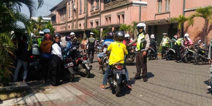 Petugas Satlantas saat menepikan dan memeriksa kelengkapan surat para pengendara sepeda motor yang terjaring operasi lalu lintas di depan SMPK Frateran Malang, Jl. Jaksa Agung Suprapto, Selasa (11/09). foto: IWAN/ BANGSAONLINE